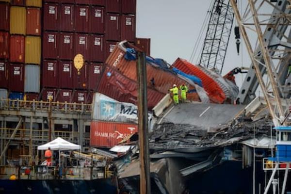 Operators work to free the ship stuck when the bridge collapsed in Baltimore on May 10.