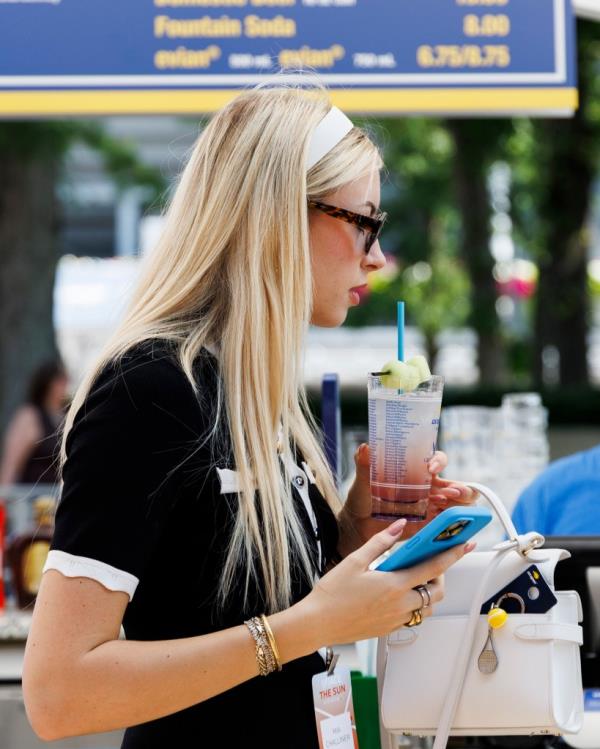 UK influencer Mia Challiner holding a Ho<em></em>ney Deuce cocktail at the 2024 US Open Champio<em></em>nships in Queens, New York