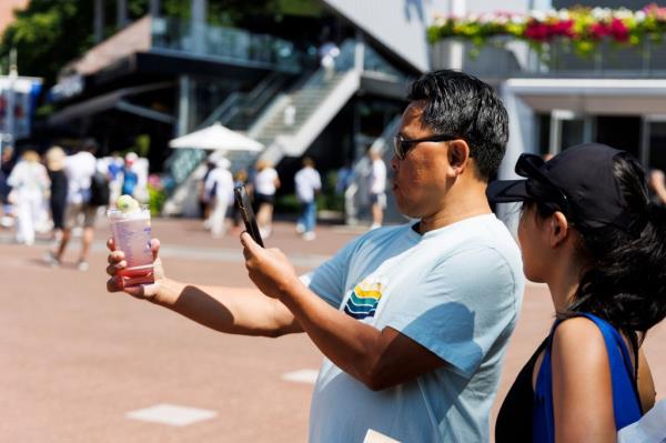 A fan photographing Ho<em></em>ney Deuce cocktails at the 2024 US Open Champio<em></em>nships in Queens, New York