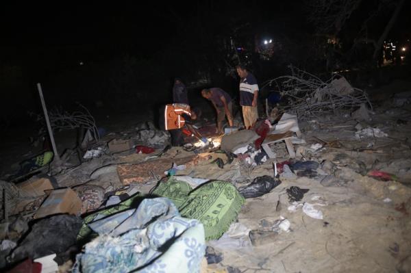 Search and rescue teams co<em></em>nducting operations at a tent encampment in Khan Yunis, Gaza following an Israeli airstrike