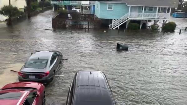 A trash can was spotted floating down a flooded street 