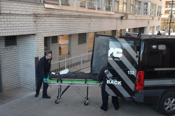 Authorities wheel out the body of the woman who died this early morning on Sutton Place. 