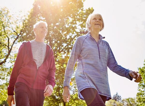 A mature couple walking together in the sunshine