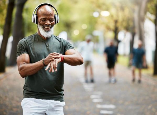 A man listens to music on headpho<em></em>nes while outside walking