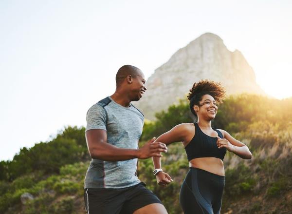 A young couple walk briskly up a hill together