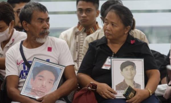 Relatives hold portraits of victims