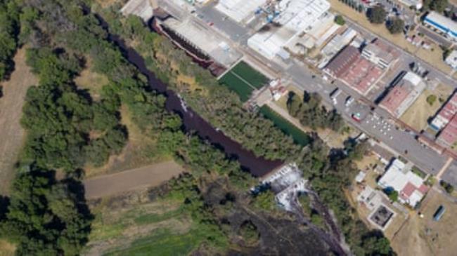 The purple waters of the Atoyac River, with the BASF factory on its bank in Puebla, Mexico.