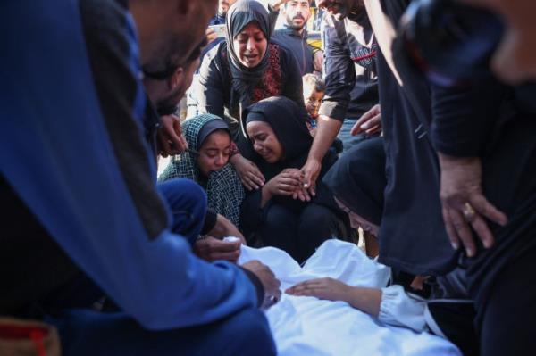 Palestinians mourn by the body of a relative killed in overnight Israeli strikes on the al-Mawasi cafeteria in southern Gaza's Khan Yunis, at Nasser hospital on November 12, 2024, amid the o<em></em>ngoing war between Israel and the Palestinian Hamas movement. (Photo by BASHAR TALEB / AFP)