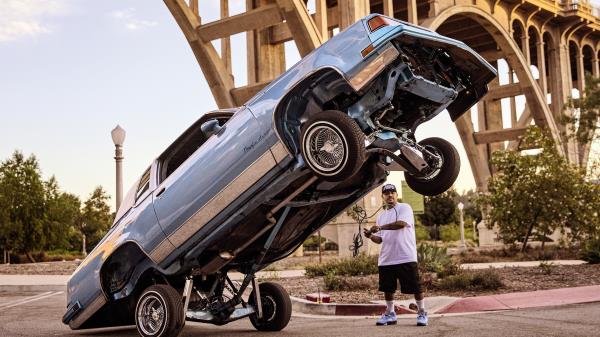 A lowrider car that has the front wheels off the ground