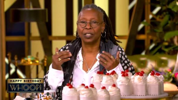 Whoopi Goldberg surrounded by cakes.