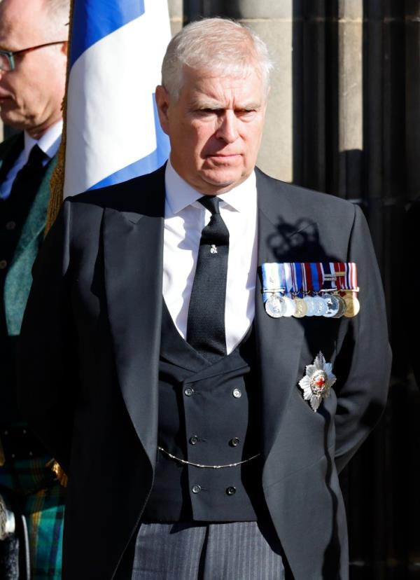 Prince Andrew, Duke of York, in a suit with medals, driving his Range Rover through the gates of his deteriorating Royal Lodge mansion.