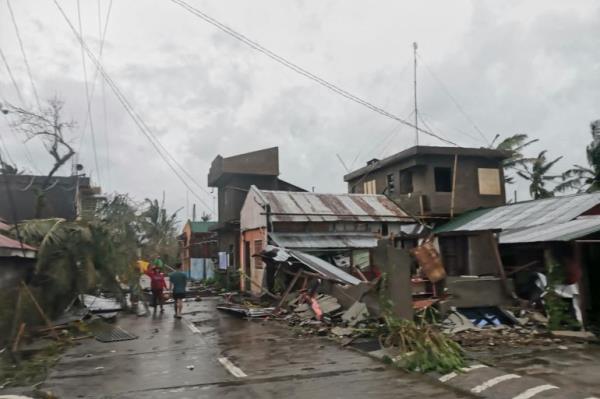 Residents walk past destroyed houses in Panganiban town in the island province of Catanduanes after the Category 5 Super Typhoon Man-yi hit overnight